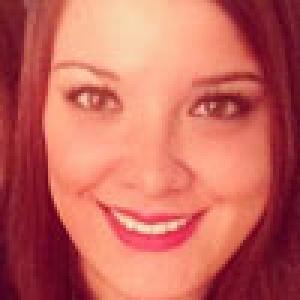 Smiling person with reddish-brown hair, close-up. This alt text was added with Al; accuracy may vary.