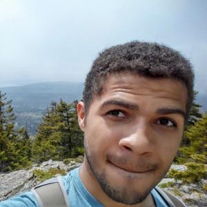 Person smiling against a plain background. This alt text was added with Al; accuracy may vary.