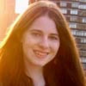 Young person saluting in a casual setting. This alt text was added with Al; accuracy may vary.