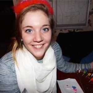 Group of five friends smiling inside a dimly lit room. This alt text was added with Al; accuracy may vary.