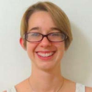 Smiling woman with glasses and short hair. This alt text was added with Al; accuracy may vary.