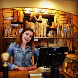 Young woman smiling outdoors in a park. This alt text was added with Al; accuracy may vary.