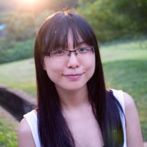 Person outdoors with glasses, long hair, soft sunset light in a grassy area. This alt text was added with Al; accuracy may vary.