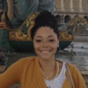 Group at mountain viewpoint wall smiles at camera against blue sky. This alt text was added with Al; accuracy may vary.