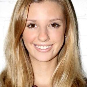 Smiling person with long blonde hair against a white background. This alt text was added with Al; accuracy may vary.