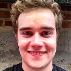 Landscape at sunset with distant factory and calm sea. This alt text was added with Al; accuracy may vary.