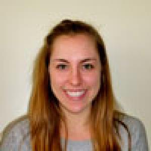 Smiling woman with long hair against a blurred background. This alt text was added with Al; accuracy may vary.