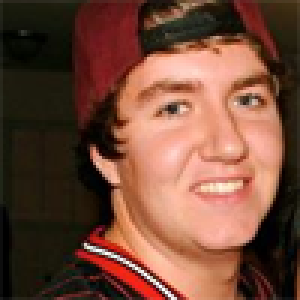 Smiling person with curly hair against a neutral background. This alt text was added with Al; accuracy may vary.