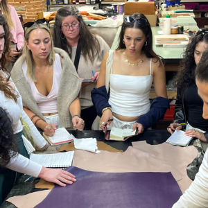 IES Abroad students examining textiles in a fashion demonstration.