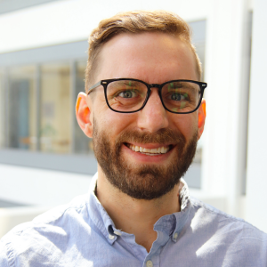  A man smiling wearing a blue shirt 