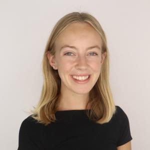Amelia Kuiper similing in front of a plain background.