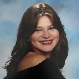 Caroline Nowik posing in front of blue background.
