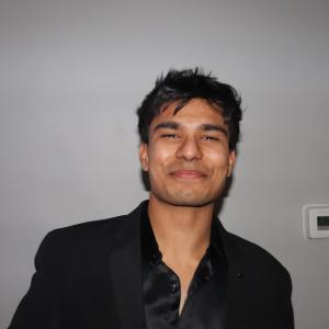 Kali Wagh posing in front of a gray background.