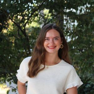 Addison Faulkners smiling in front of trees