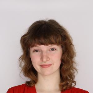 Eleanor Cooper-Ohm smiling in front of a white background.