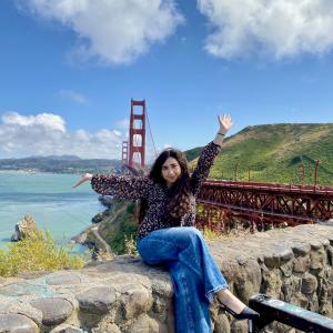 Heba Khayyat posing in front of a blue sky with clouds.