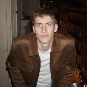 Luke Parks staring at the camera in front of a blurry background.