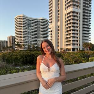 Maddy Czopek smiling in front of skyscraper buildings.