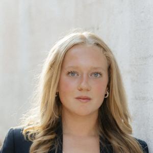 Olivia Boerger posing in front of white textured background.