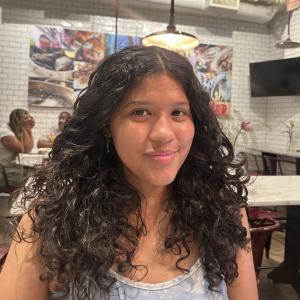 Natalia Torres smiling in a cafe.