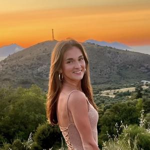 Olga Brzecka standing in front of a sunset by a hill