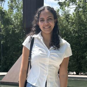 Zinab Mohamed smiling in front trees.