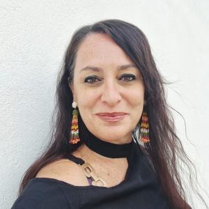 Faculty Coordinator Daira poses wearing a black shirt.