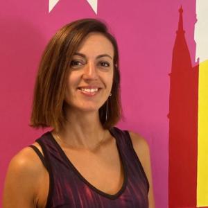 Administration Assistant Elisa poses wearing a black tank top.