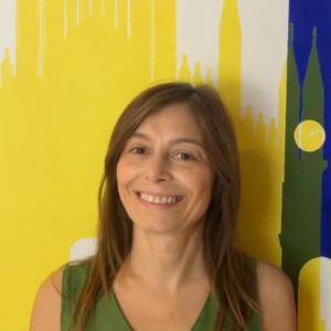 Assistant Director Luisa poses wearing a green tank top.
