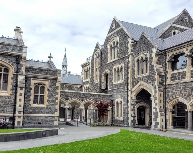 Dark gray, classic European style buildings sit on the University of Canterbury's Campus.