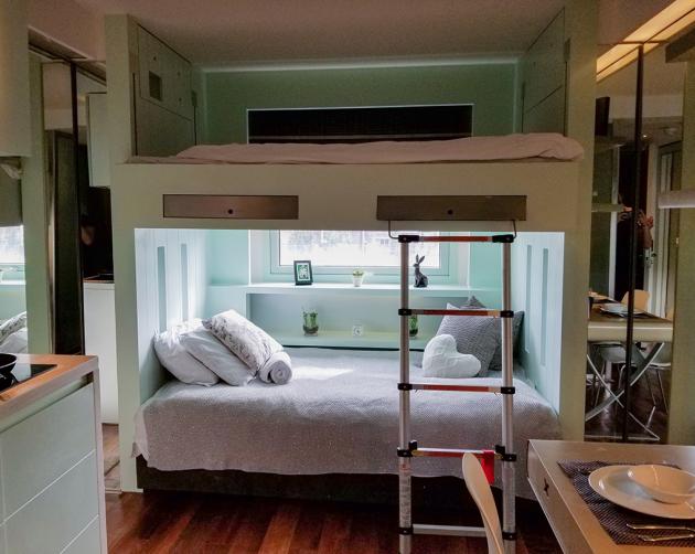 A clean double bunk bed sitting in the hallway between living spaces. 