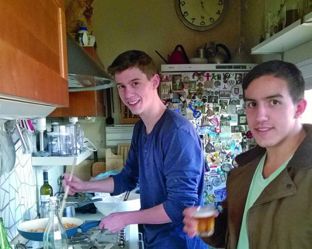 Two students cook in a small, rustic kitchen in Milan.
