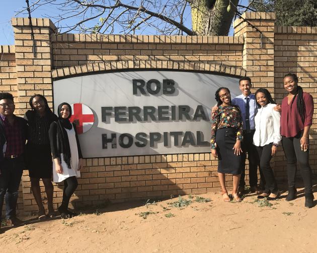Seven students standing in front of a Rob Ferreira Hospital sign in Cape Town