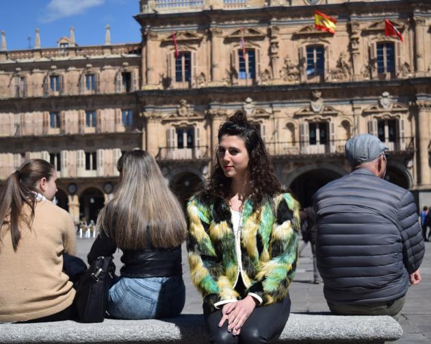 Student sits in Salamanca with a fashionable jacket on
