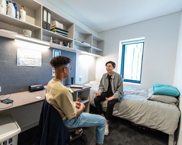 Two students socializing inside of an Auckland housing placement