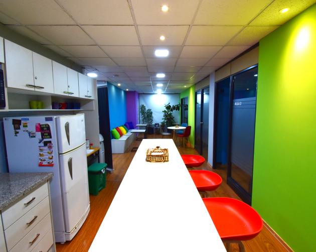 A photo of the inside of our colorful and vibrant Center in Quito, featuring a kitchenette and seating area