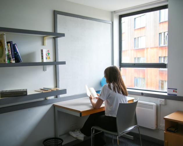 Student sitting at desk in her dorm room