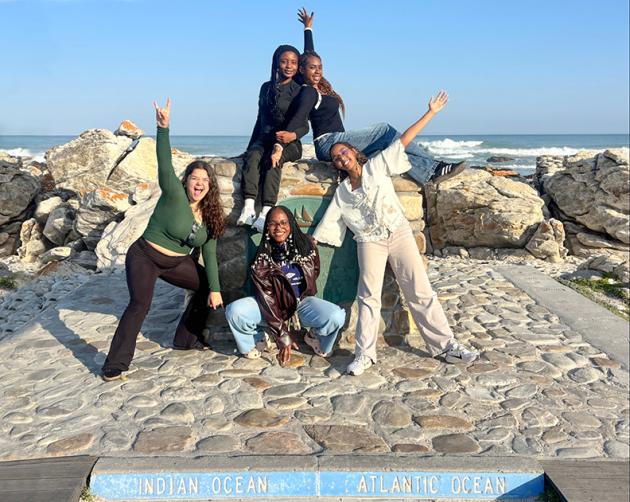 FIve students posing where the Indian Ocean meets the Atlantic Ocean