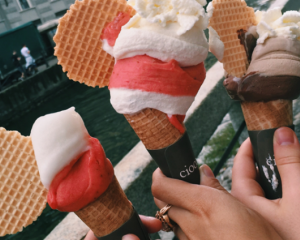 three hands holding gelato cones