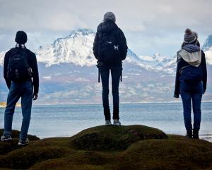 three people looking at the mountains 