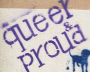 an image with a graffiti saying "queer proud"