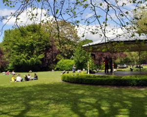 sunny dublin with people sitting on the grass in the park