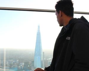 a guy looking at the view from the skyscraper 