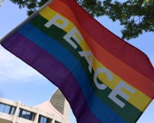 an LGBTQ flag saying "peace"