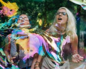 Two students are distorted behind an iridescent bubble.