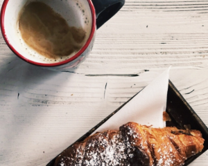 birds eye view of coffee cup and croissant