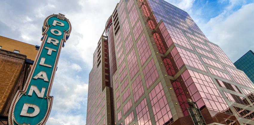 Iconic Portland sign with pink skyscraper rising next to it