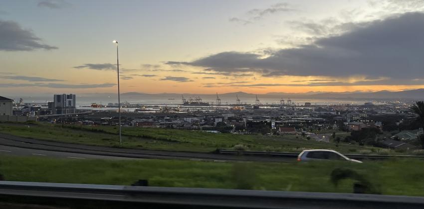 An image of sunrise, road, and cars. 