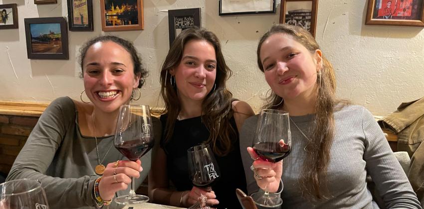 3 female students facing with camera with red wine glasses