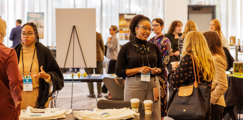 IES Abroad staff talking with participants at a conference.